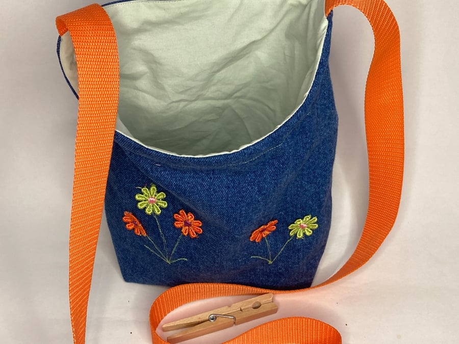 Repurposed denim peg bag with flower decoration and orange strap