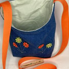 Repurposed denim peg bag with flower decoration and orange strap