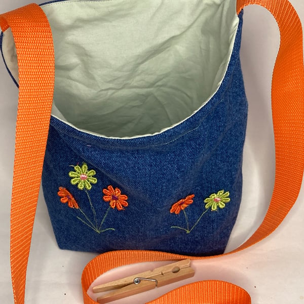 Repurposed denim peg bag with flower decoration and orange strap