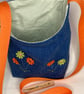 Repurposed denim peg bag with flower decoration and orange strap
