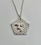 Silver bee necklace on a honeycomb background