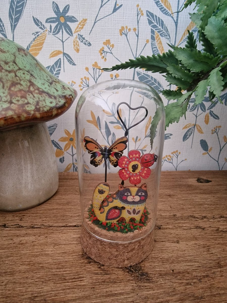 A Glass dome with a cute cat in the garden scene