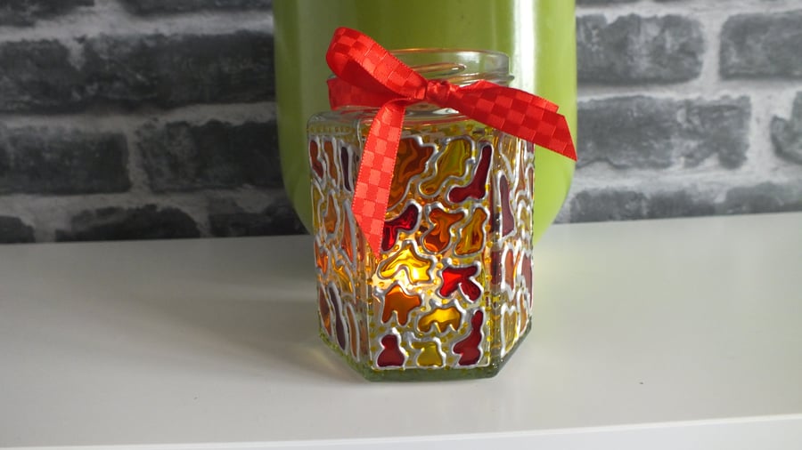 Tea light holder finished with glass paints and ribbon