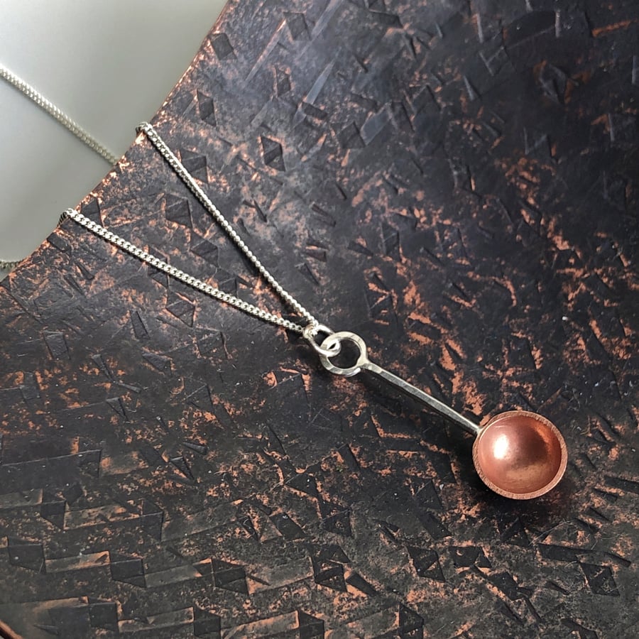 Sterling silver and copper spoon pendant.