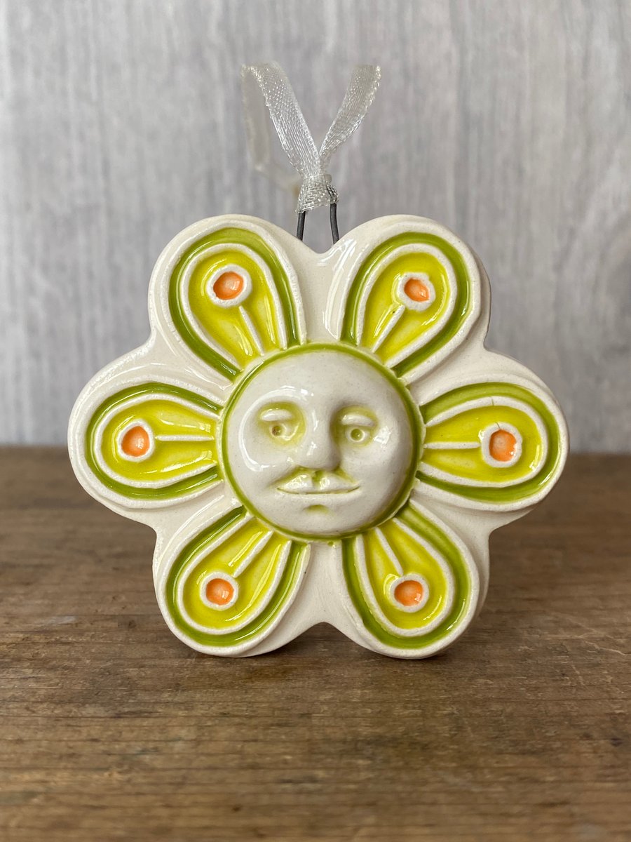 Intricate ceramic flower decoration with face green