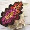 Embroidered oak leaf brooch.