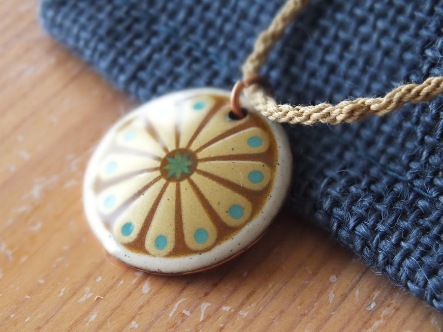 Folky wheel design enamelled pendant