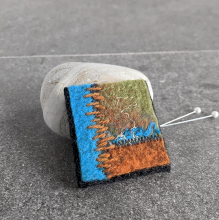 Felted patchwork brooch in shades of orange and turquoise