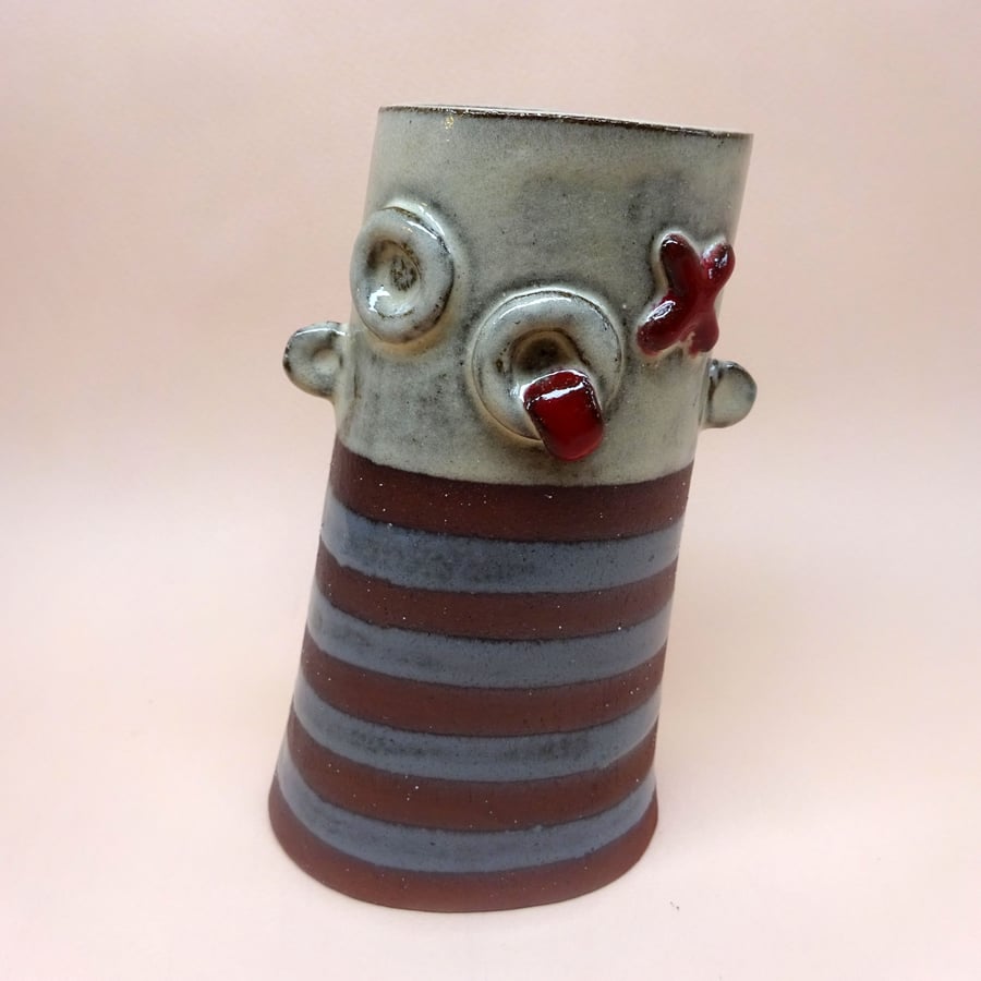 Ceramic face pot with sticking out ears and stripy grey top