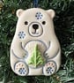 Ceramic polar bear carrying a Christmas tree decoration