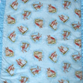 Mr and Mrs Bunny tossed on a turqoise cot quilt