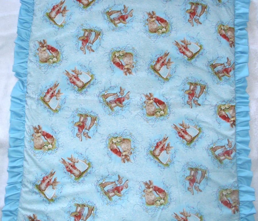 Mr and Mrs Bunny tossed on a turqoise cot quilt