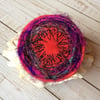 Individual silk embroidered circular brooch. 
