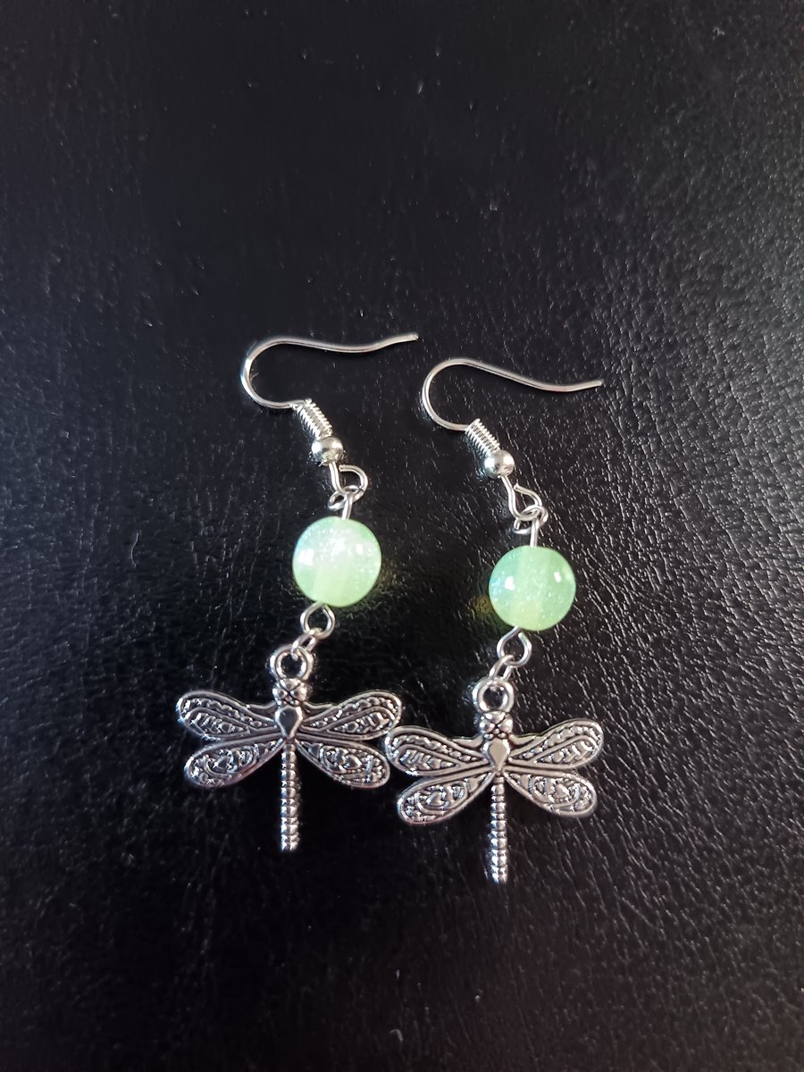 Silver dragonfly charm dangle earrings with green bead detail