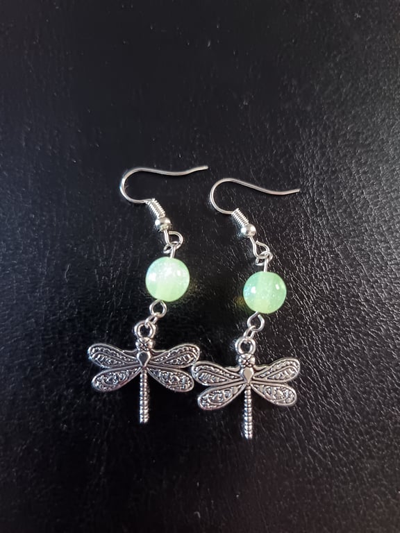 Silver dragonfly charm dangle earrings with green bead detail