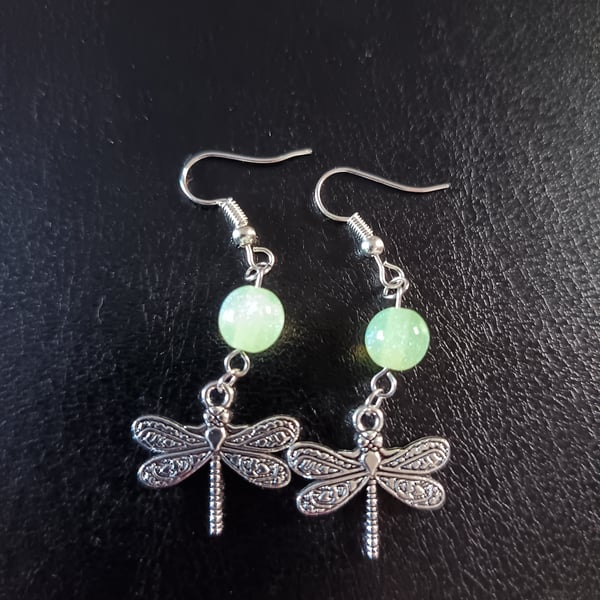 Silver dragonfly charm dangle earrings with green bead detail