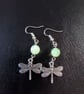 Silver dragonfly charm dangle earrings with green bead detail