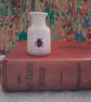 Miniature stoneware bud vase with ladybird decoration