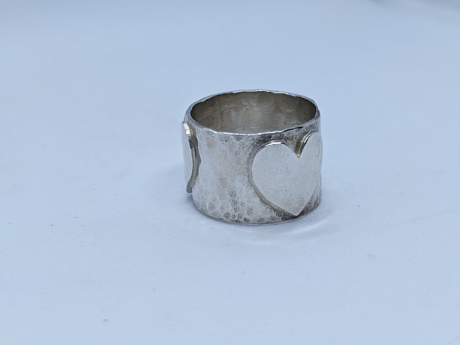 Handmade sterling silver band ring with three silver hearts