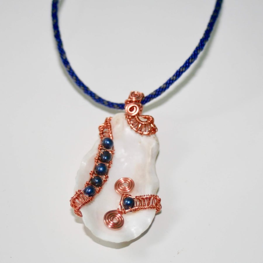 Wire-wrapped oyster shell with blue pearls