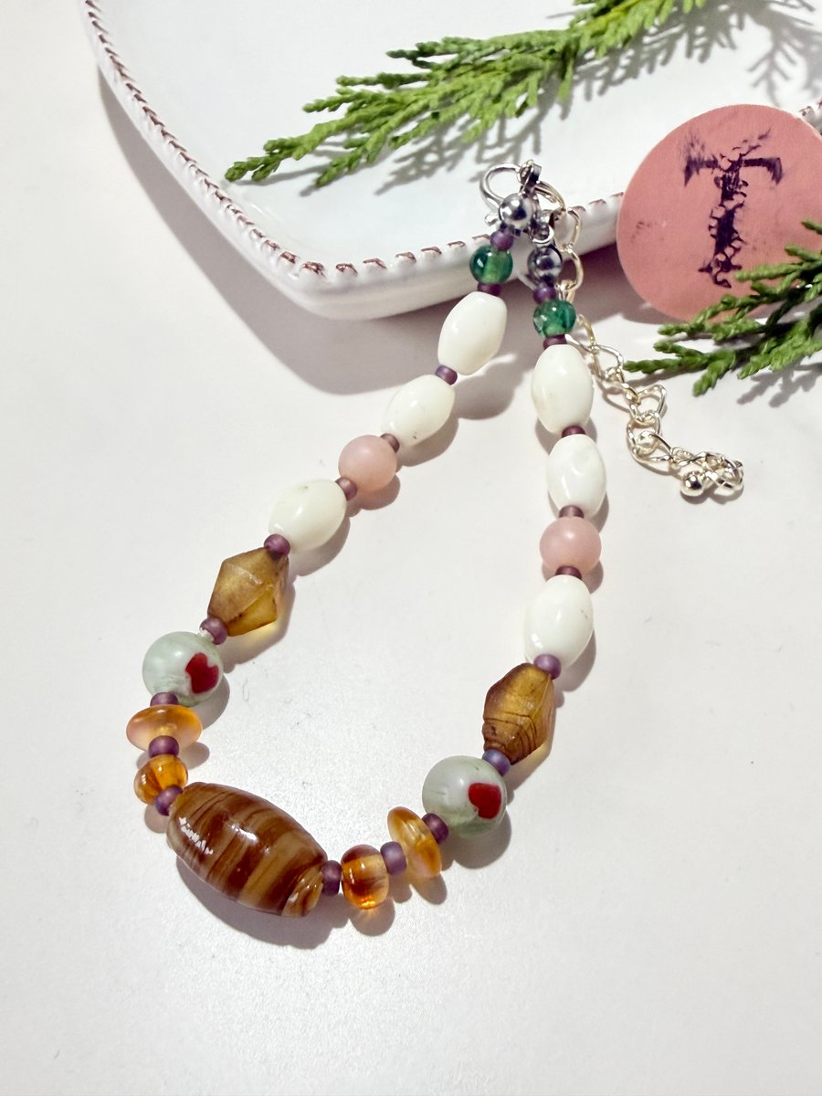 Delicate glass bead bracelet in neutral colours with extender chain.