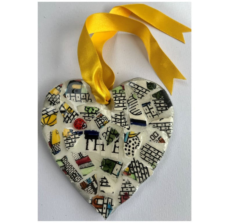 A heart shaped mosaic pendant with stylistic walls and the letters T, H and E.