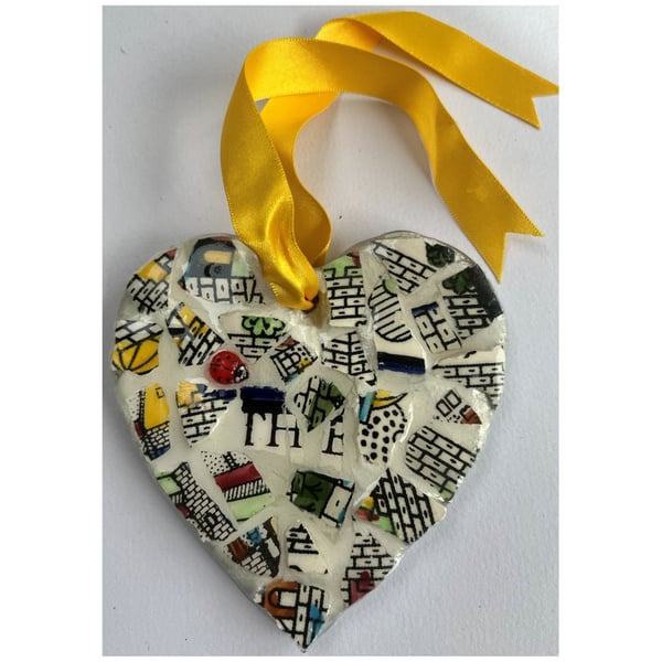 A heart shaped mosaic pendant with stylistic walls and the letters T, H and E.