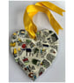 A heart shaped mosaic pendant with stylistic walls and the letters T, H and E.