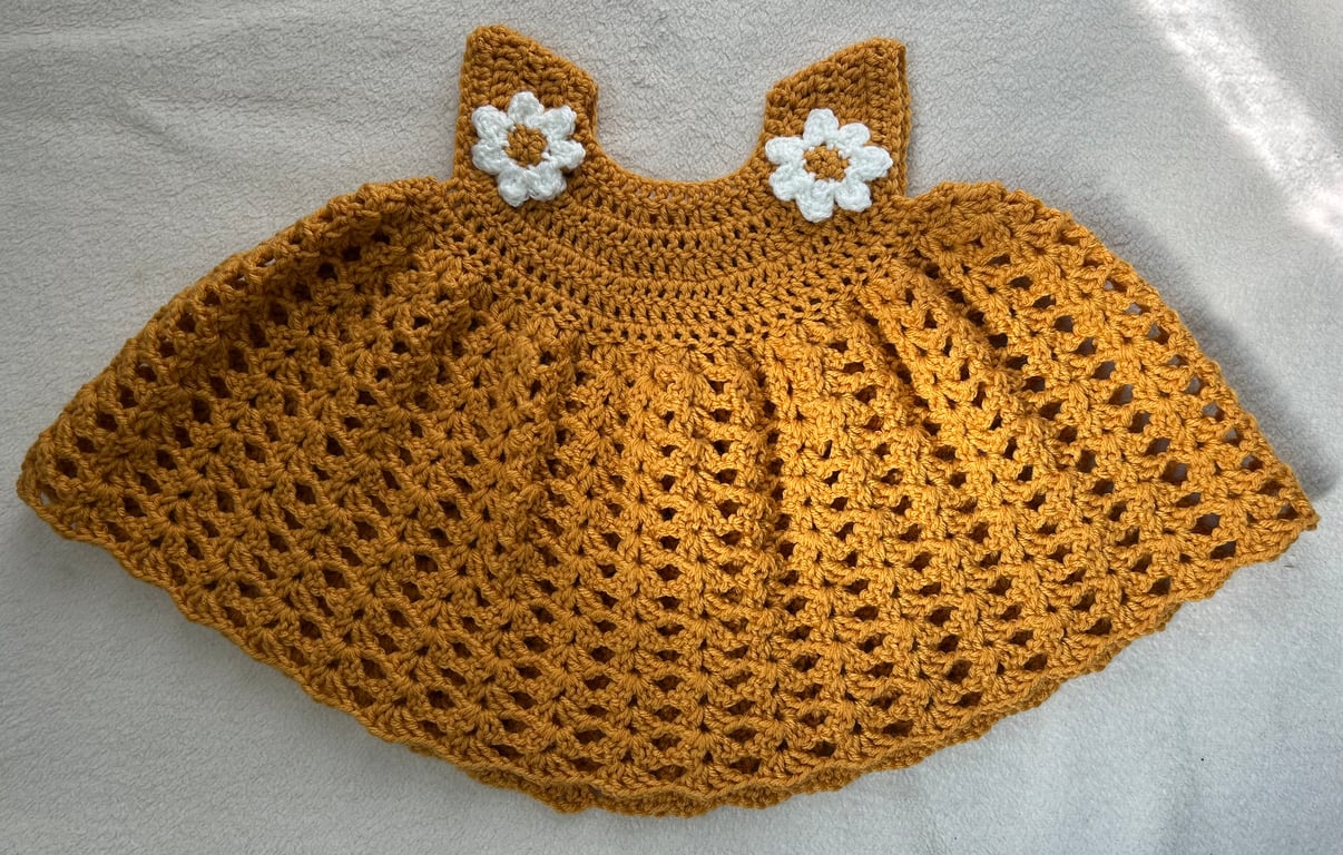 Baby dress in golden yellow with daisies.