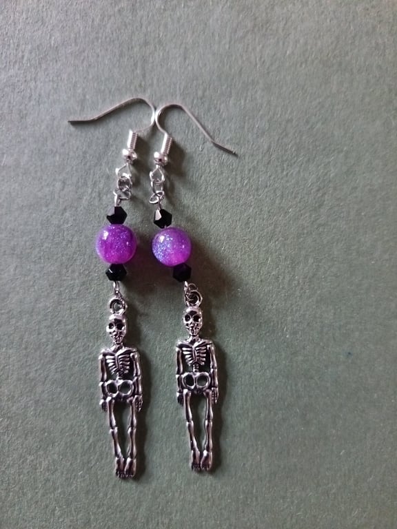 Silver skeleton dangle earrings with purple and black beads