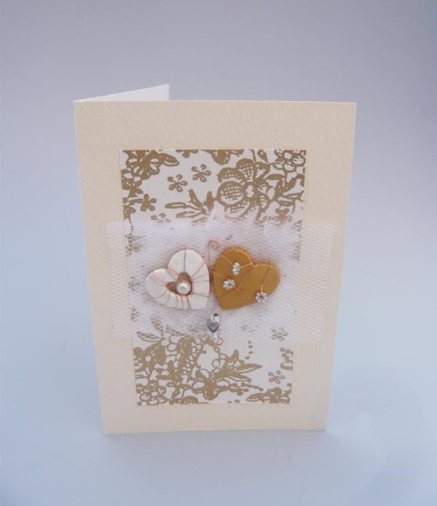 Wedding card with small white and gold hearts.