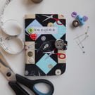 Sewing needle case in sewing-themed fabric