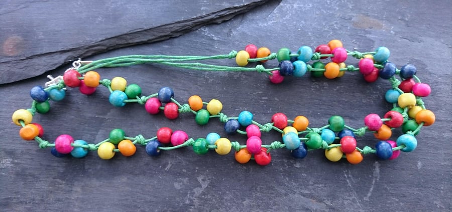 Rainbow wooden necklace on bright green cotton cord