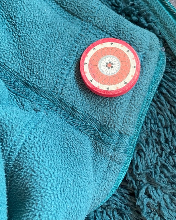 Wooden brooch with warming colours 