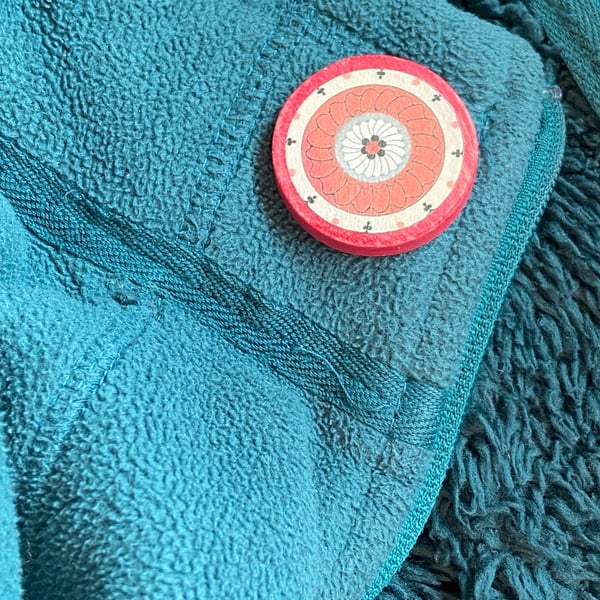 Wooden brooch with warming colours 