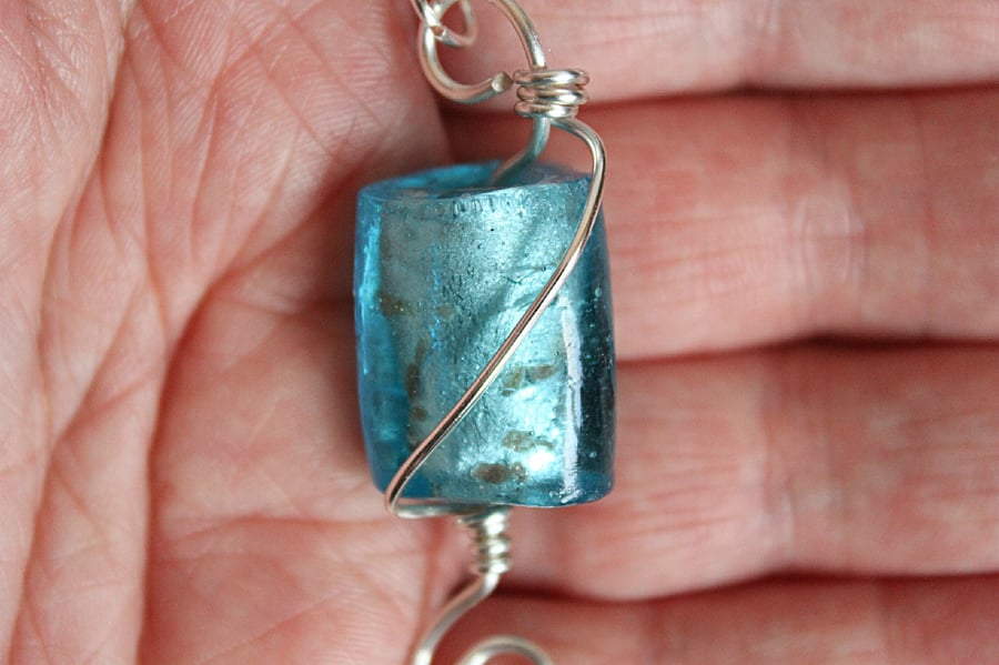 Light blue triangular prism foiled glass bead wrapped in silver wire pendant