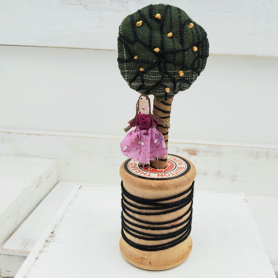 Teeny tiny fabric tree and teeny tiny lady on a vintage bobbin