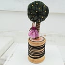 Teeny tiny fabric tree and teeny tiny lady on a vintage bobbin
