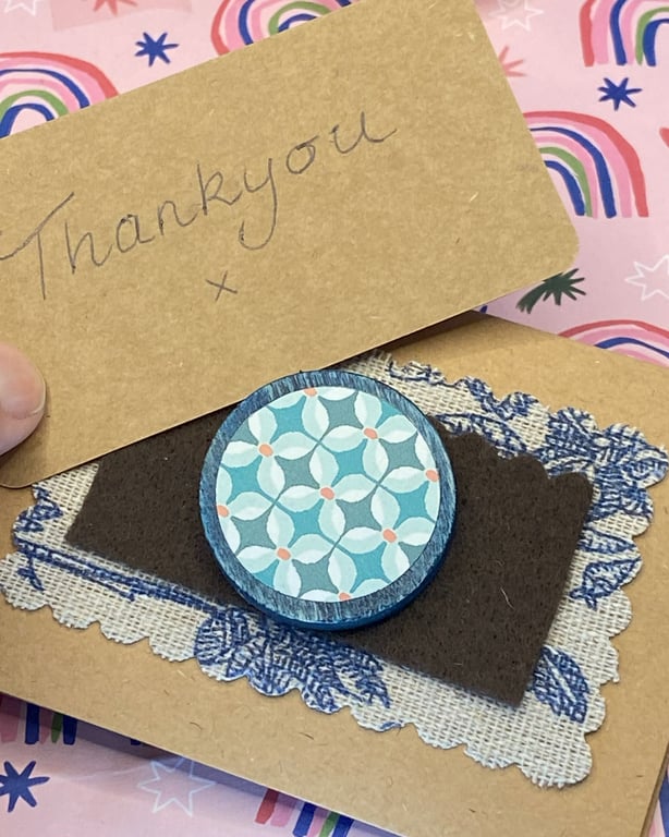 Wooden brooch with a repeated floral pattern