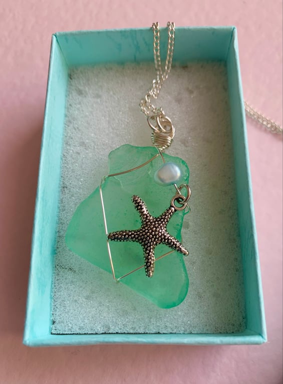 Beautiful handcrafted aqua sea glass pendant with silver starfish.  Unique gift.