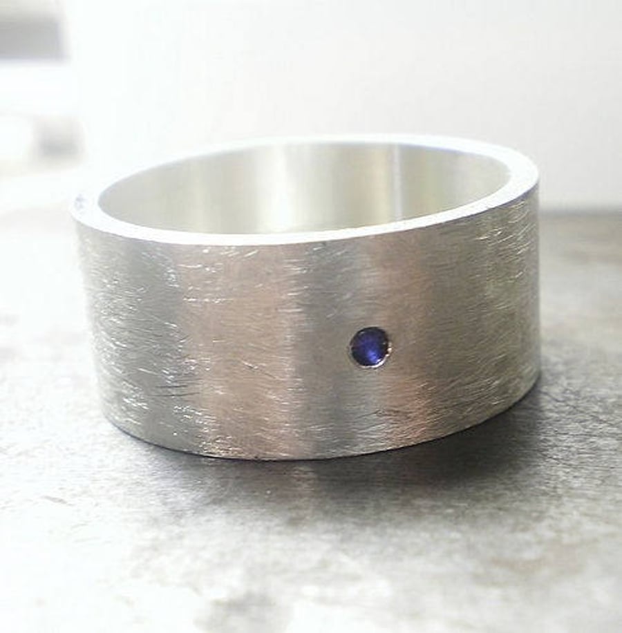 Large flat silver ring with a single blue sapphire , celebrate your love one