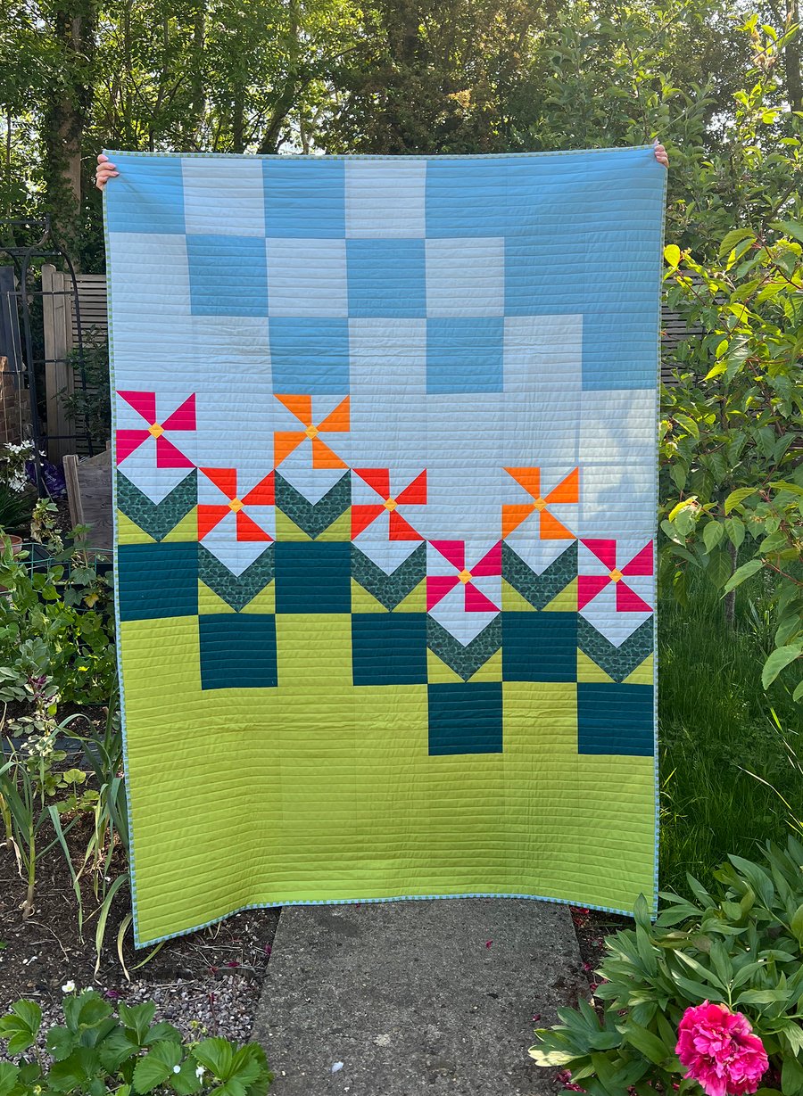 Geometric pink & orange flowers on single bed patchwork quilt