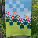 Geometric pink & orange flowers on single bed patchwork quilt