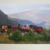 Photographic greetings card of a Welsh Highland Railway steam train in dark red.