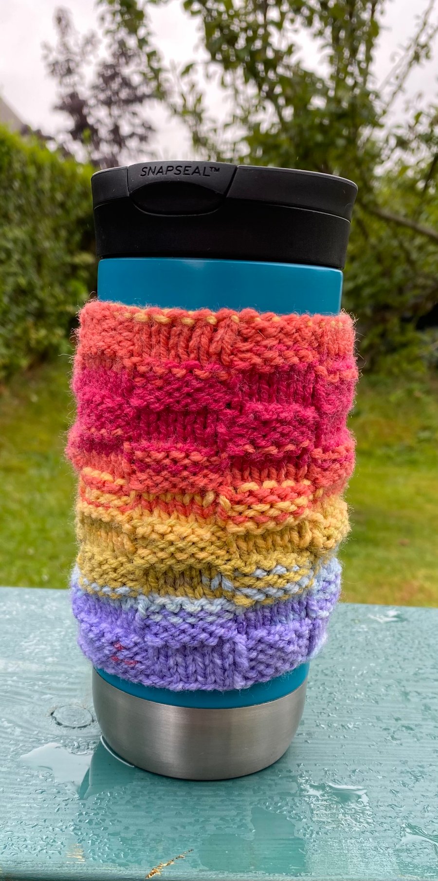 Handknitted travel mug colourful rainbow cosie