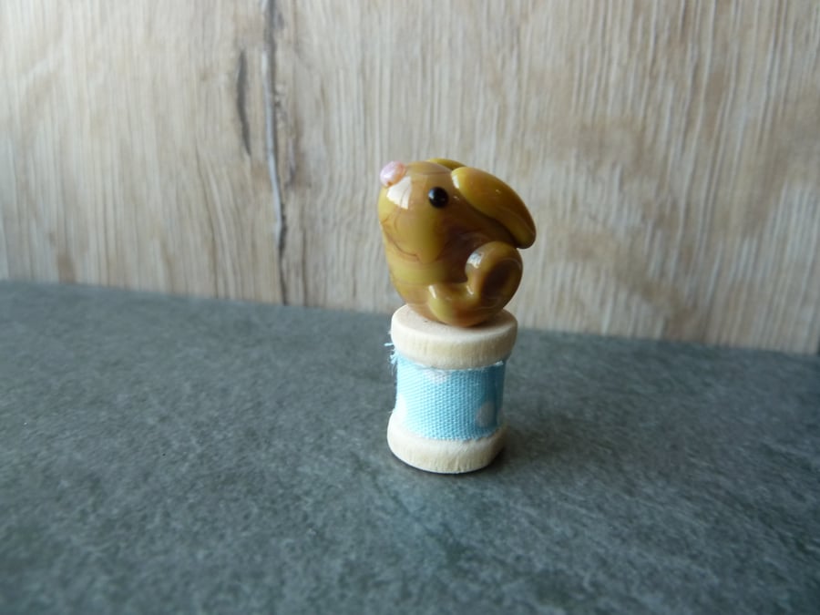 glass hare on wooden spool