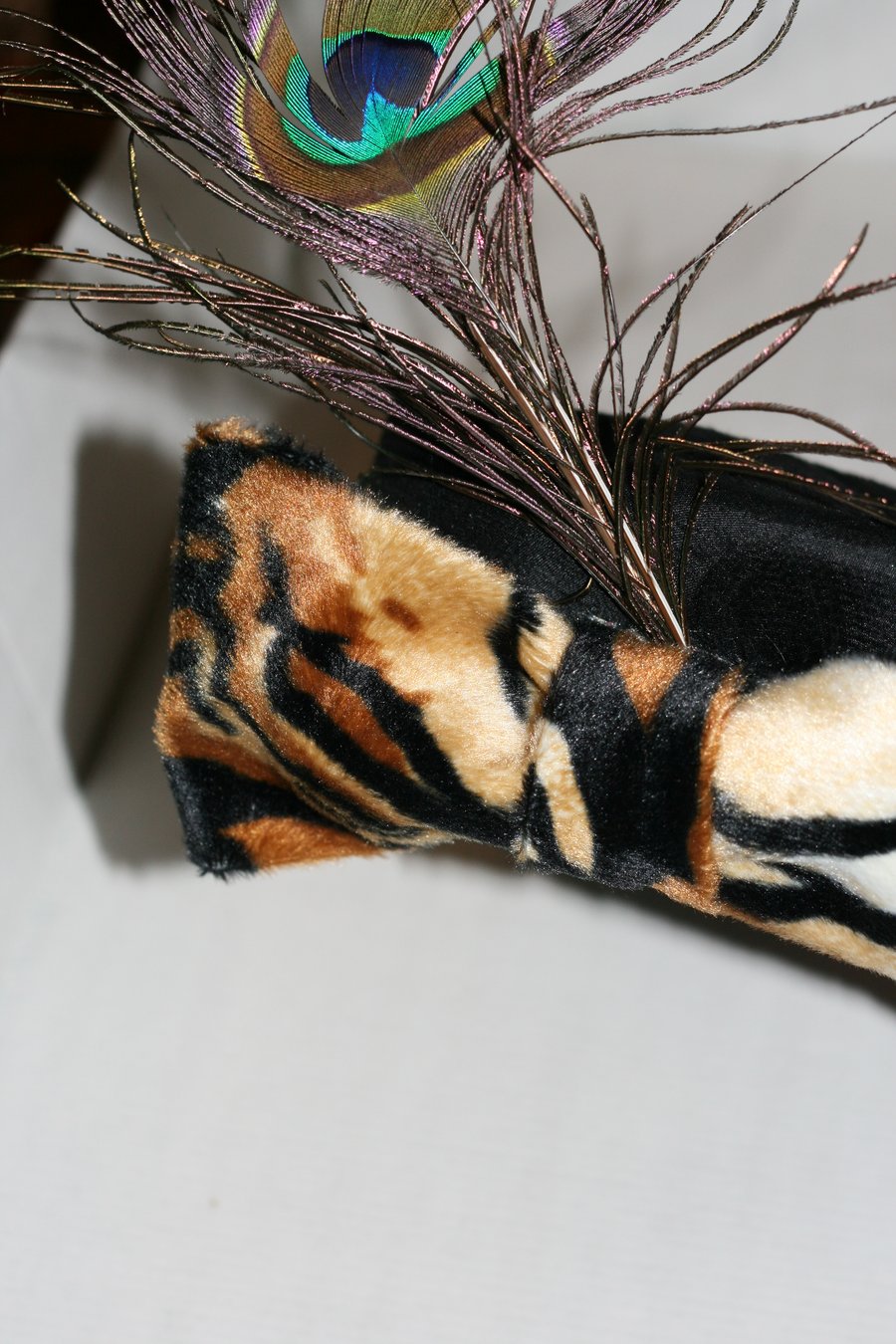 Black hat with tiger bow and peacock feather