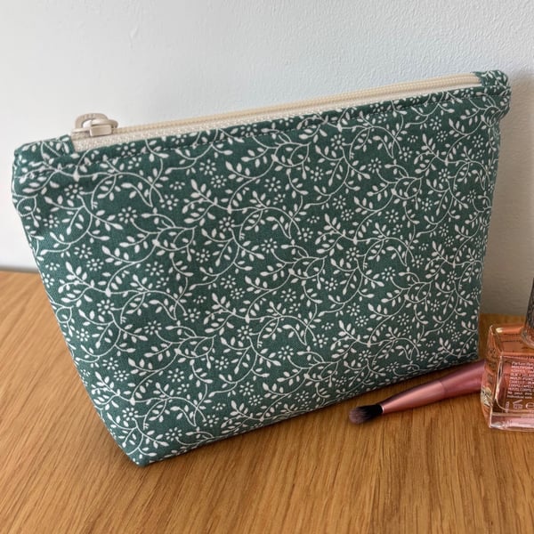 Small cotton makeup bag, pouch, purse, in a green and cream floral design.