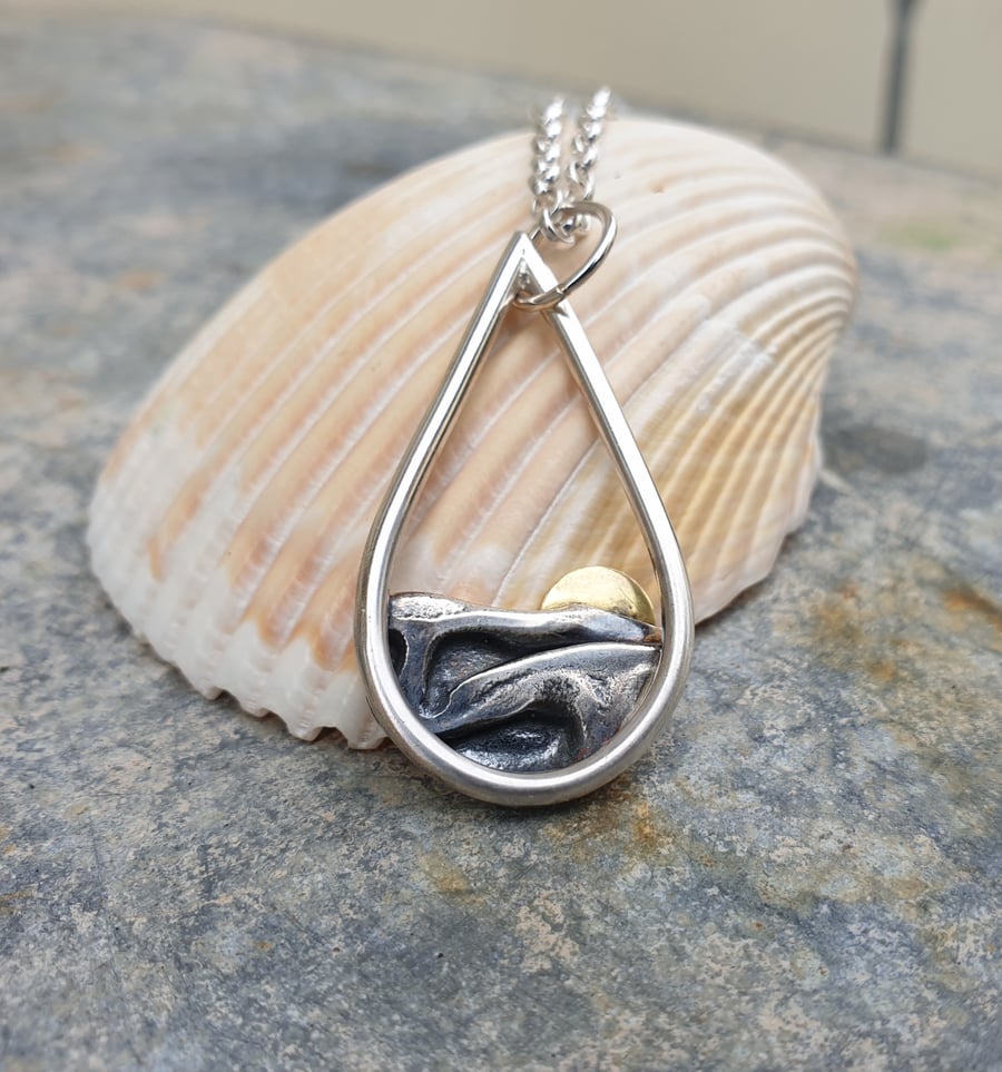 Silver sun rising over sea pendant