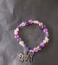 Elasticated pastel goth beaded bracelet with skull and butterfly charm - Image 1